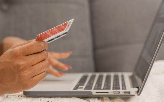 Close-up of a person using a credit card for online shopping on a laptop.