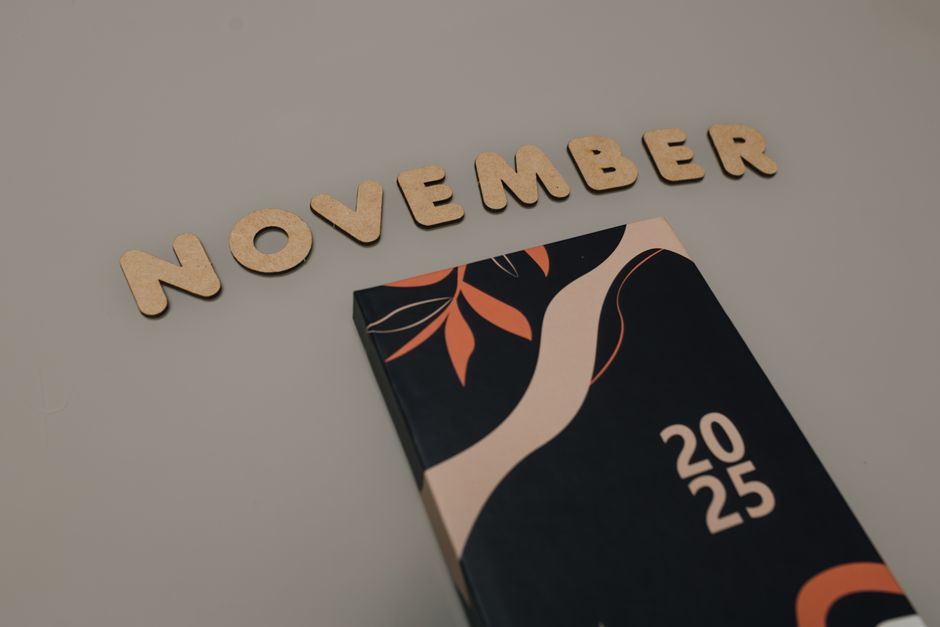 Wooden letters spelling 'November' with a 2025 planner, minimal design.