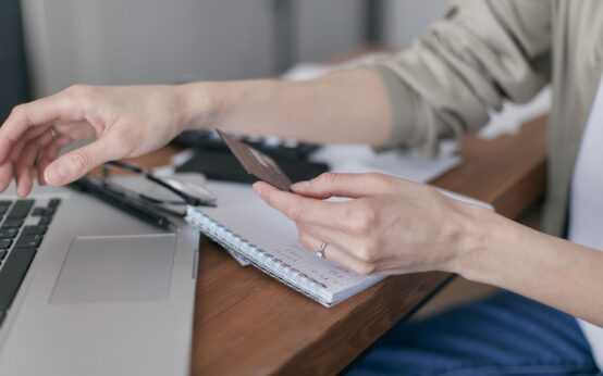 A person using a credit card on a laptop for online shopping or payment.