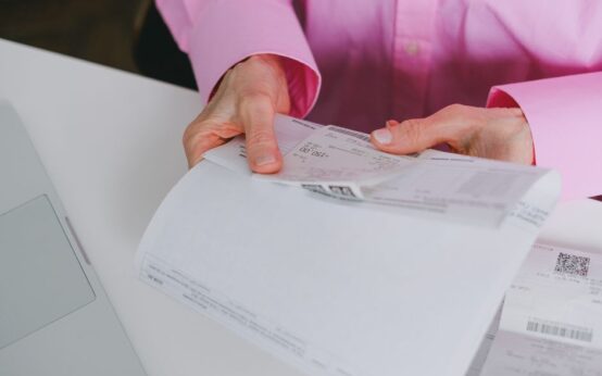Business person handling paper receipts, meticulously organized.